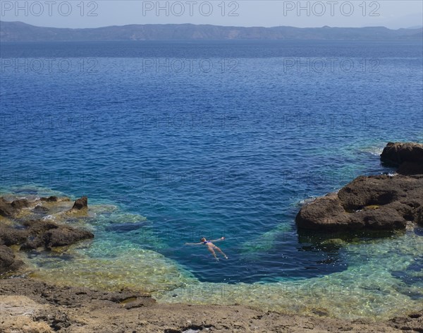 Hispanic woman floating in ocean