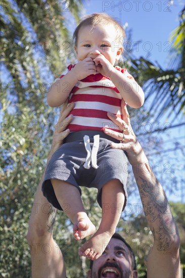 Mixed race father holding baby outdoors