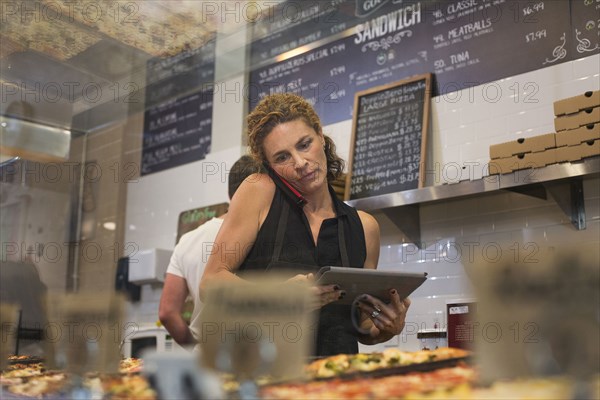 Caucasian woman talking on cell phone in cafe