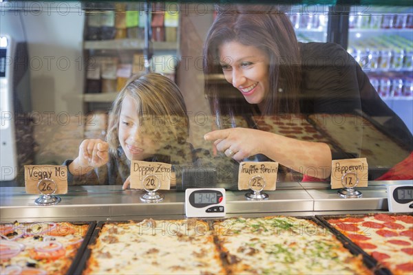 Mother and daughter choosing pizza in cafe