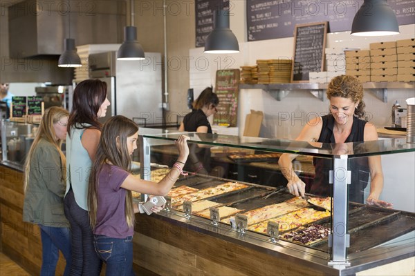 Customers choosing pizza in cafe