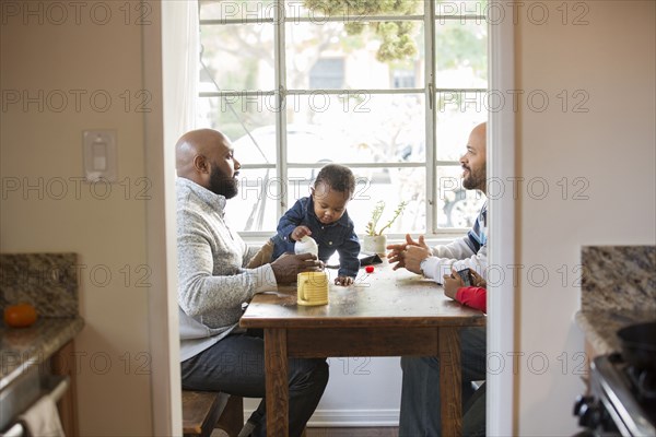 Fathers and children sitting at table