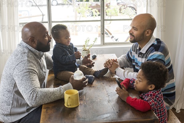 Fathers and children sitting at table