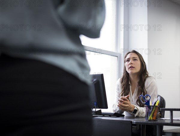 Caucasian businesswomen talking in office