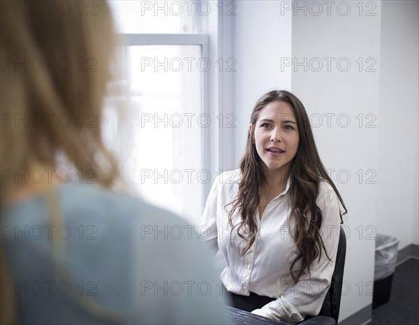 Caucasian businesswomen talking in office