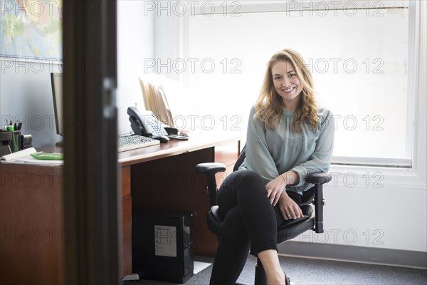 Caucasian businesswoman smiling in office