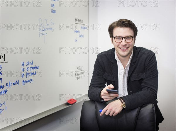 Caucasian businessman using cell phone in office