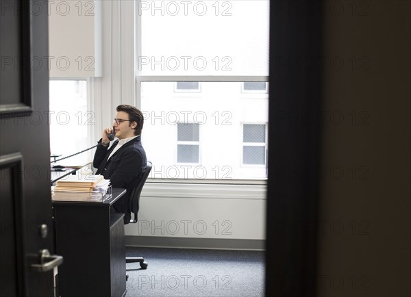 Caucasian businessman talking on telephone in office