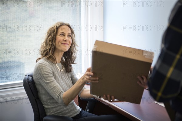 Caucasian businessman delivering packages in office