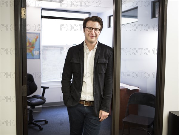 Caucasian businessman smiling in office doorway