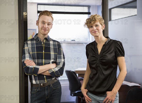 Caucasian business people smiling in office doorway