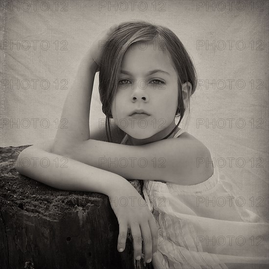 Close up of girl leaning on tree stump