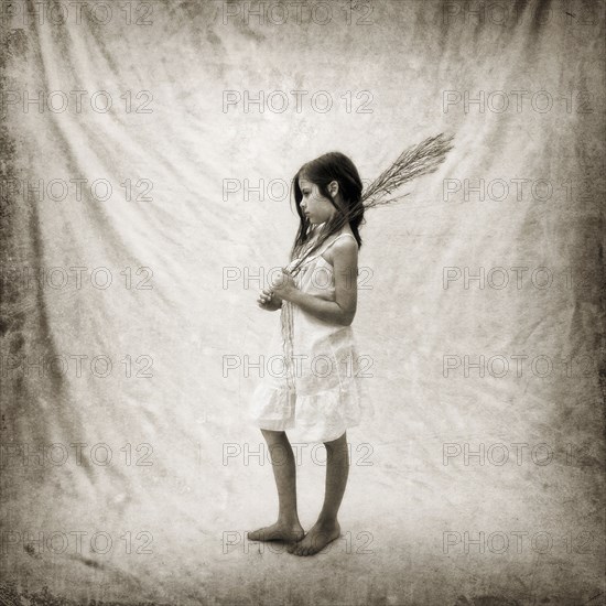 Photograph of girl holding branch on fabric