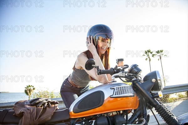 Caucasian woman in helmet sitting on motorcycle