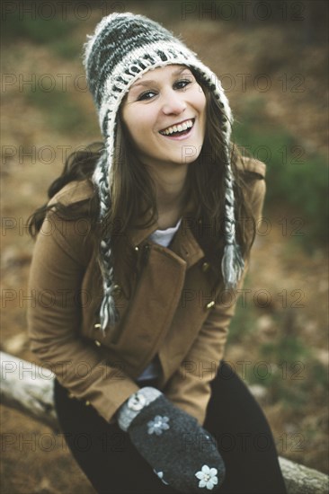 Caucasian woman sitting on wooden log