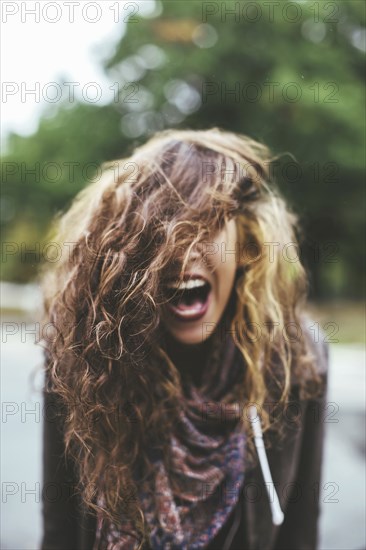 Shouting Middle Eastern woman tossing her hair outdoors