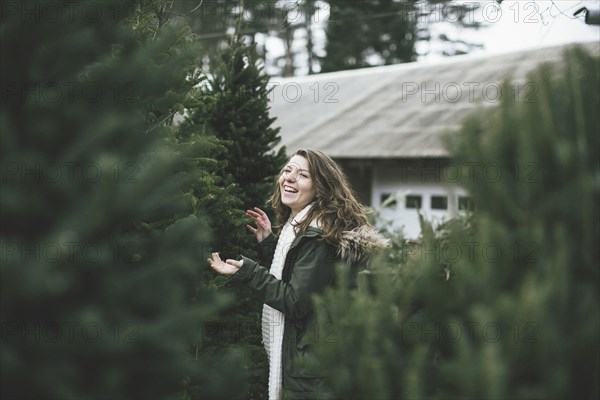 Caucasian woman walking in Christmas tree lot