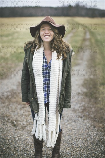 Caucasian woman smiling on dirt path in rural field