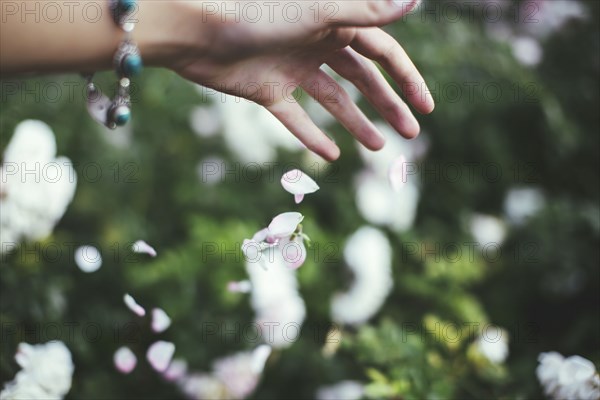 Caucasian woman playing with flower petals