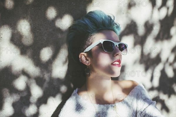 Stylish Caucasian woman wearing sunglasses in shade