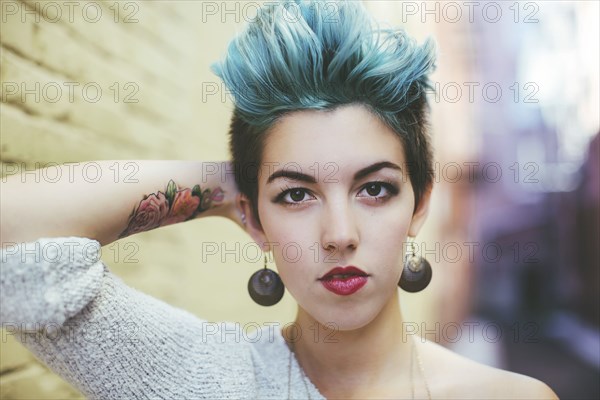 Stylish Caucasian woman with earrings and dyed hair