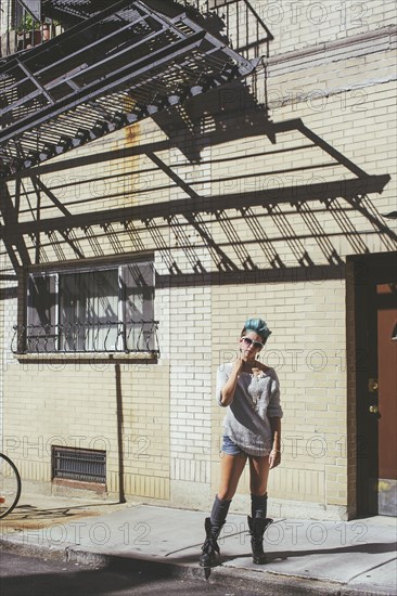 Caucasian woman standing on city sidewalk