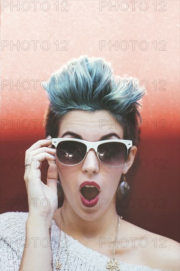 Surprised Caucasian woman with sunglasses and dyed hair