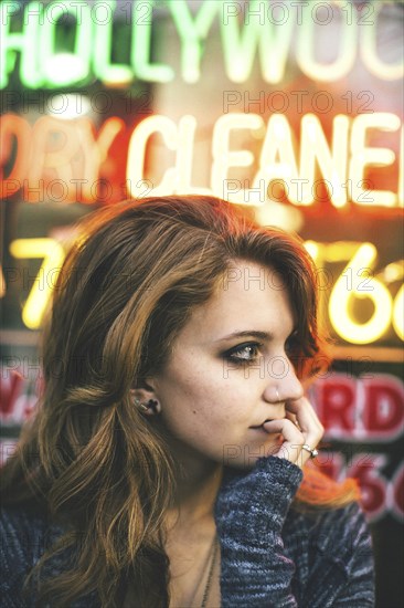 Caucasian woman standing in front of neon sign