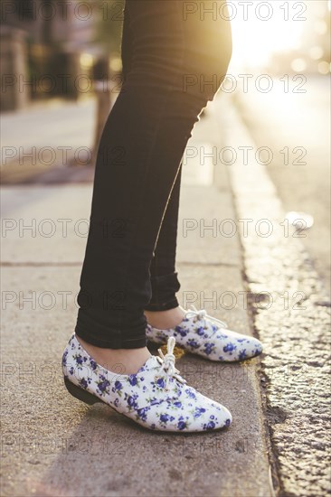 Caucasian woman wearing patterned shoes on city sidewalk