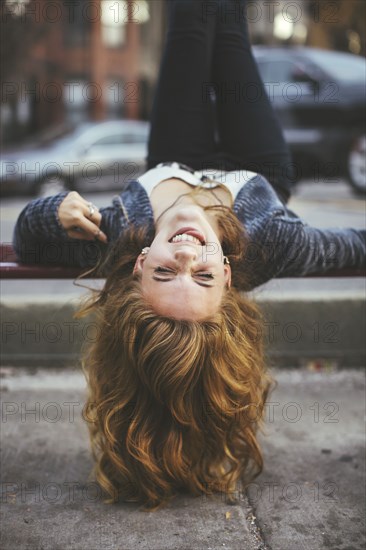 Caucasian woman laying on city sidewalk