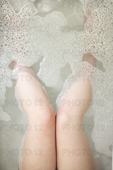 High angle view of legs of woman soaking in bathtub