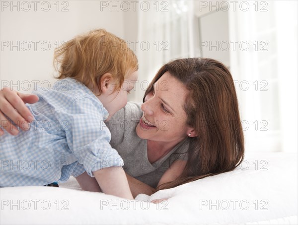 Mother and son playing on bed