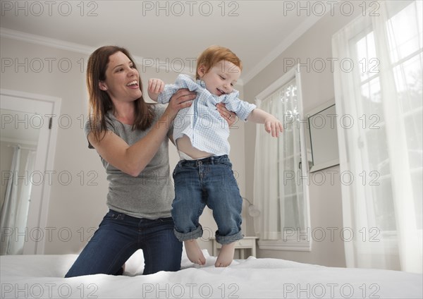 Mother and son playing on bed