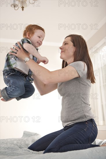 Mother and son playing on bed