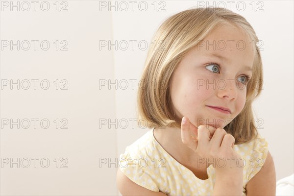 Caucasian girl resting chin in hand