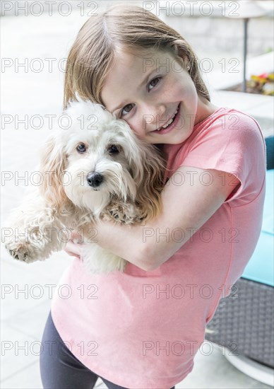 Close up of Caucasian girl hugging puppy