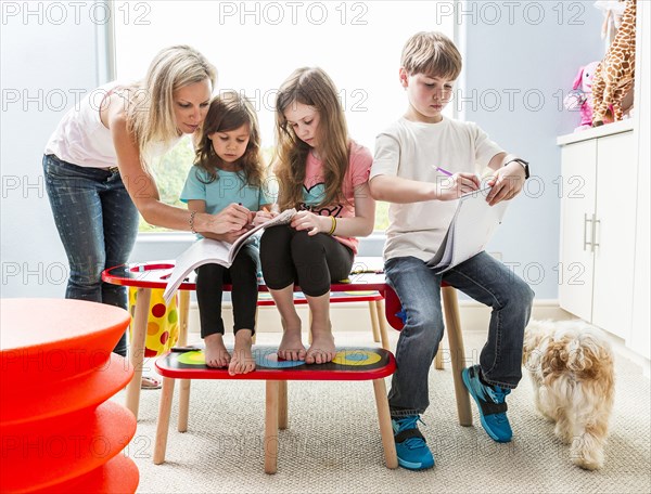 Caucasian family drawing at table in playroom