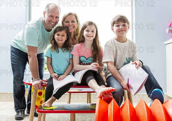 Caucasian family smiling at table in playroom