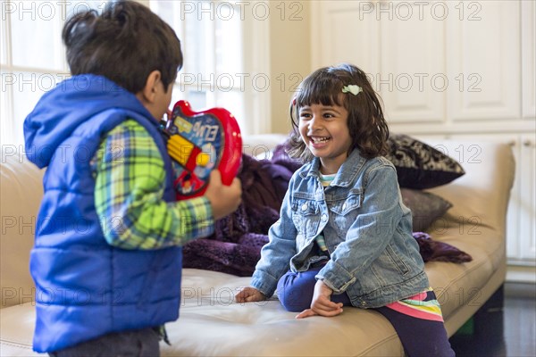 Brother and sister playing with toy in living room