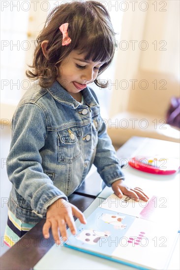 Close up of girl reading book at table