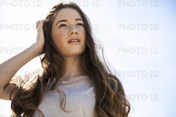 Caucasian woman standing under blue sky