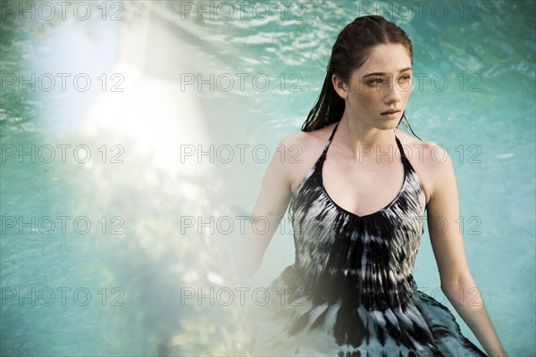 Caucasian woman wearing dress in swimming pool