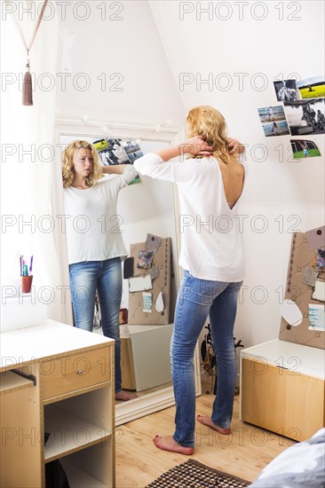 Woman styling her hair in mirror