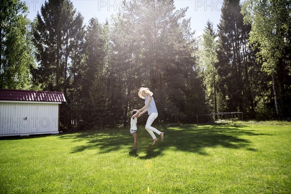 Mother playing with son in backyard