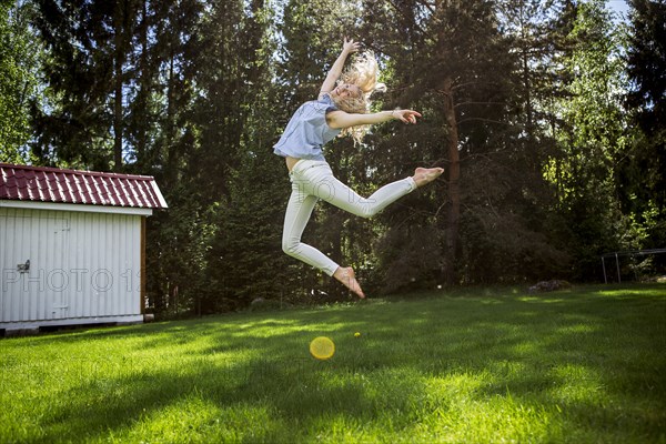 Woman jumping for joy in backyard