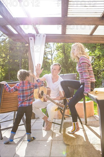 Father and son high-fiving on backyard patio