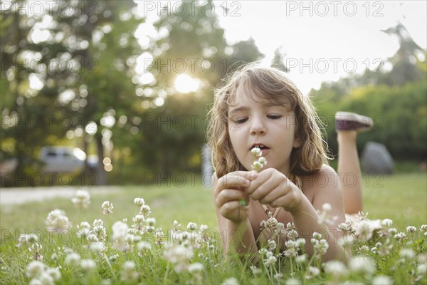 Caucasian girl playing with flowers in backyard