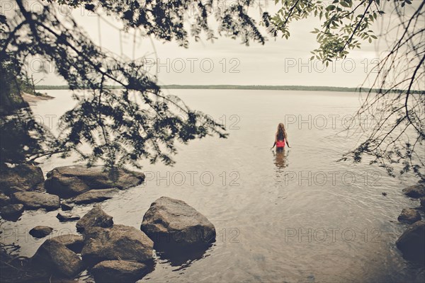 Caucasian girl standing in remote lake