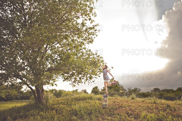 Caucasian girl picking fruit in orchard