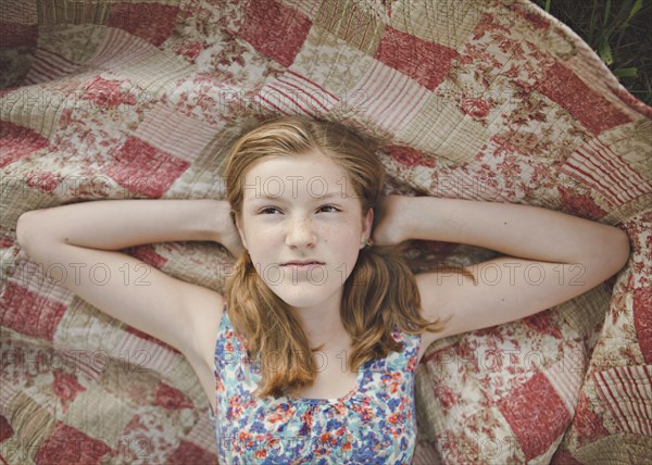 Caucasian girl laying on blanket